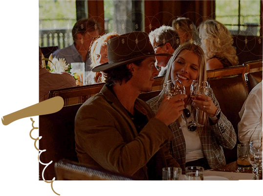 Couple toasting man wearing western style hat